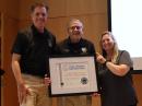 ARISS representatives Frank Bauer, KA3HDO (middle), and Jackie Blumer, KC9LEH (right), accepted the Challenger-7 Recognition from Challenger Center's Mike Kincaid (left) during the organization's 40th anniversary celebration. [Challenger Learning Center photo]
